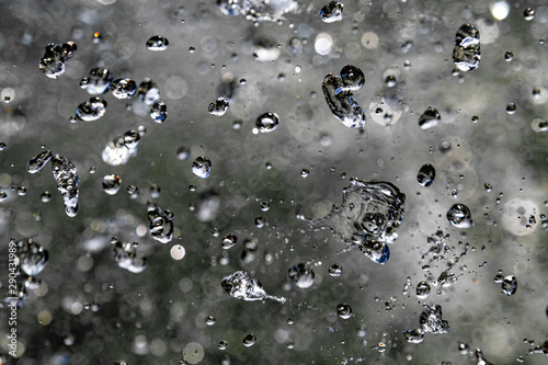 Drops of water are limited on a dark background. Splash of water drops frozen in the air on a black background.