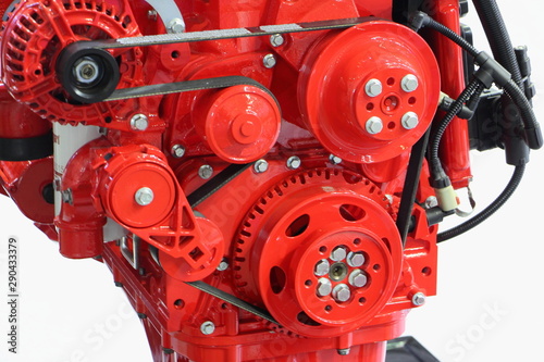Close up fragment of new red truck engine, pulleys with auxiliary drive belt of powerful turbo motor front view © Ilya