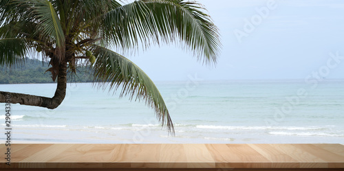 Empty rustic desk with beautiful tropical ocean with coconut tree in the background