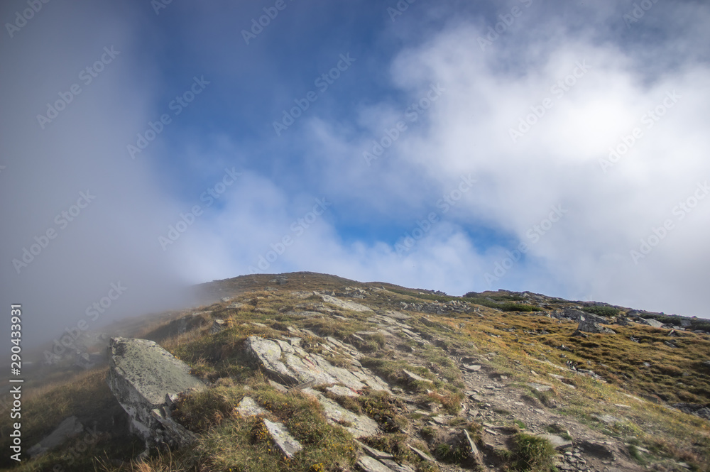 Fototapeta premium Mountains covered in fog in autumn day
