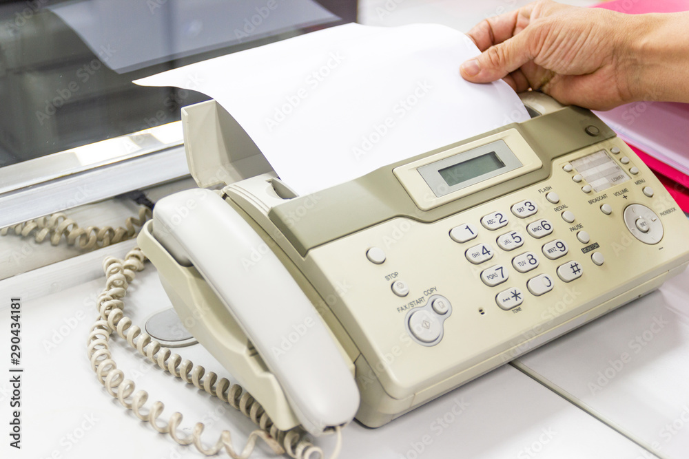 hand man are using a fax machine in the office, equipment for data transmission. hand man are using a fax machine in the office, equipment for data transmission.