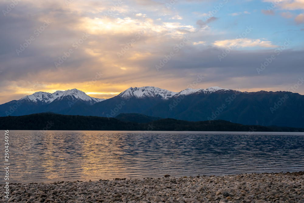 Fototapeta premium Sunset over the snow capped souther alps by the lake