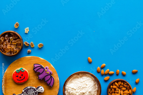 spooky halloween figures with flour, sugar, almond for cooking treat on blue background top view mock up