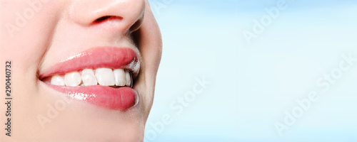 Smiling woman mouth with great white teeth on a blue background