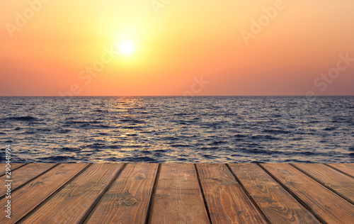 Empty wooden table against the sunset on the sea. © MaskaRad