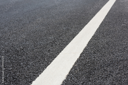 A white paint on a clean and tidy black asphalt road slash low angle close-up space background
