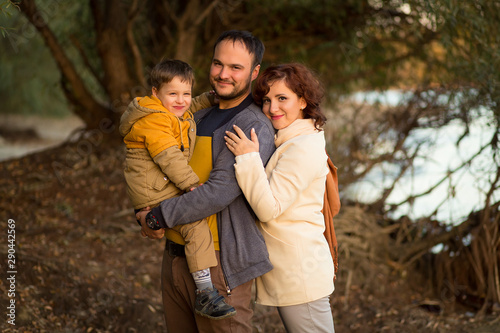 happy family mom dad and son on a walk in the autumn in the park