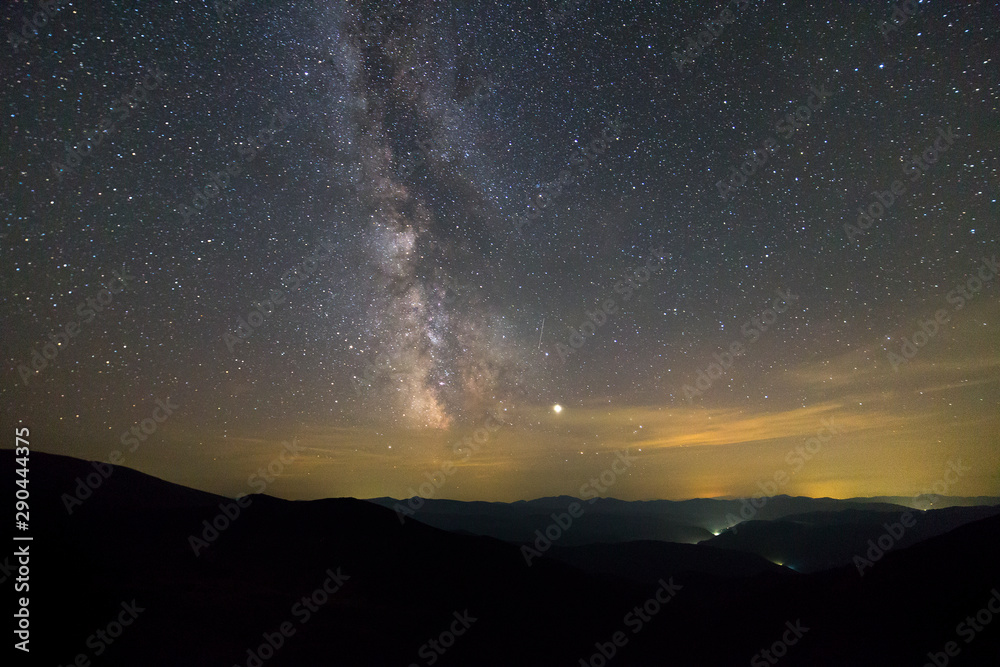 Night landscape of mountains with stars covered sky .