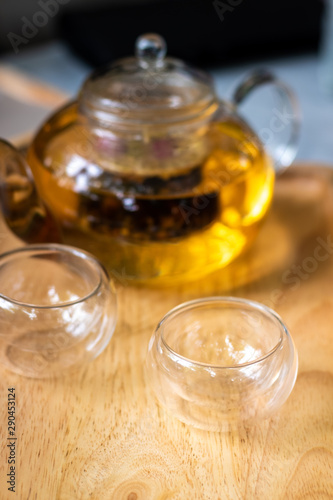 Focus of cup of tea with teapot background on the table .Process brewing tea,tea ceremony,Cup of freshly brewed tea,The Time of Tea Break.