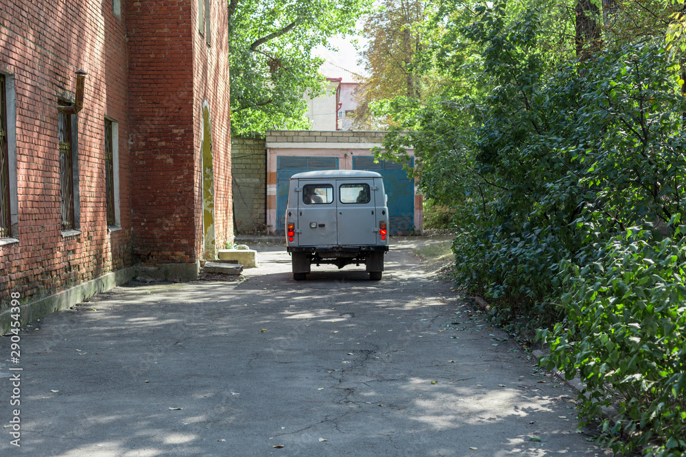 Back of old cargo van next to a brick building.