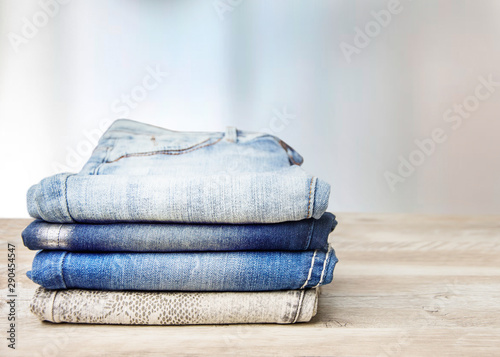  Pile of jeans on a wooden table