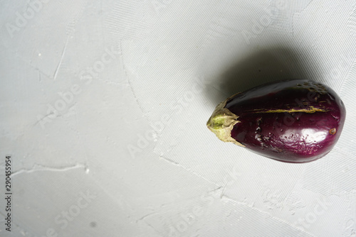 Trendy ugly organic eggplant on grey table, with copy space photo