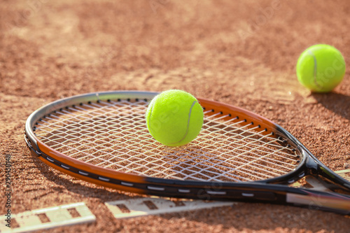 Racket and balls on tennis court © Pixel-Shot