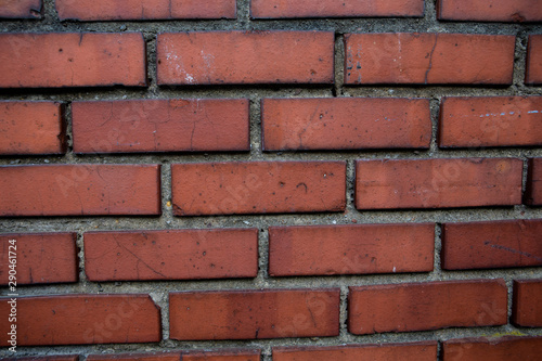 Old red brick wall. Old concrete wall. The facade of the house built of solid stone cement