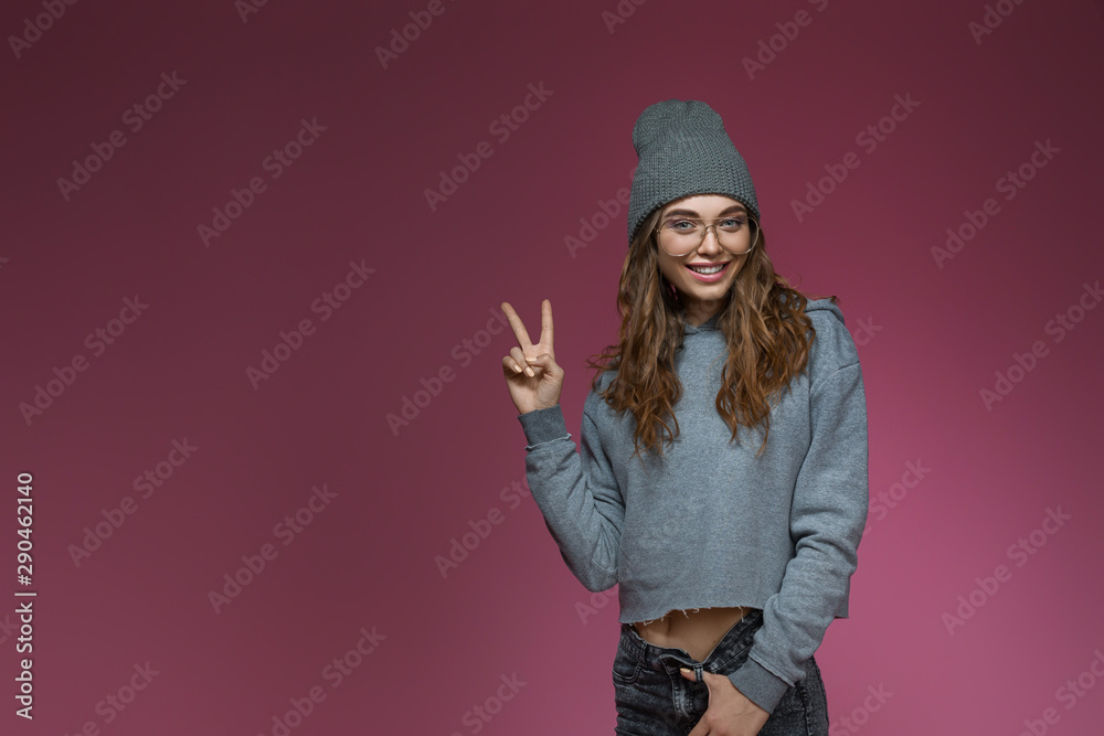 beautiful smiling woman in gray hat and stylish glasses posing on pink background. copy space beautiful smiling woman in gray hat and stylish glasses posing on pink background. copy space