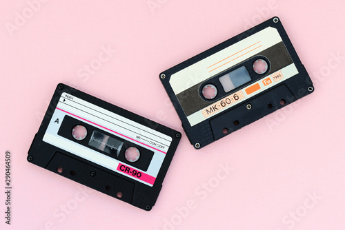 Old audio tape cassettes on a pink background. Top view, old technology concept