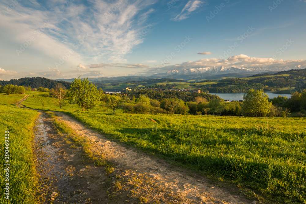 Obraz premium Panorama of snowy Tatra mountains and castle in Czorsztyn during spring sunset, Malopolskie, Poland
