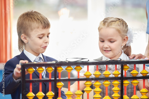 teacher teaches children mental arithmetic using large abacus soroban
