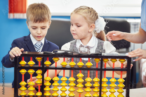 teacher teaches children mental arithmetic using large abacus soroban