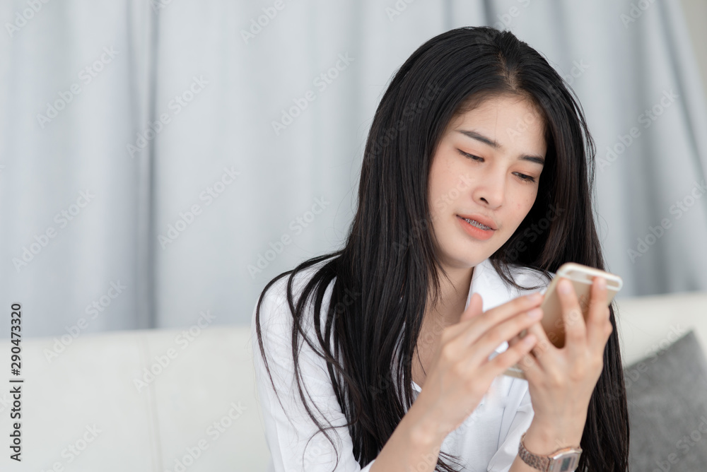 Asian woman relaxing on sofa and using smart phone at home, lifestyle concept. Asian woman relaxing on sofa and using smart phone at home, lifestyle concept.