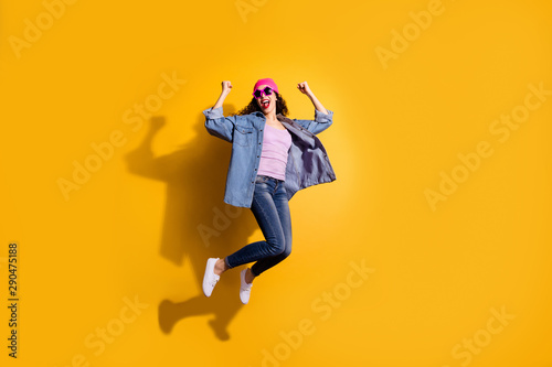 Full body photo of funky lady jumping high overjoyed by discount shopping prices wear casual trendy clothes isolated yellow color background