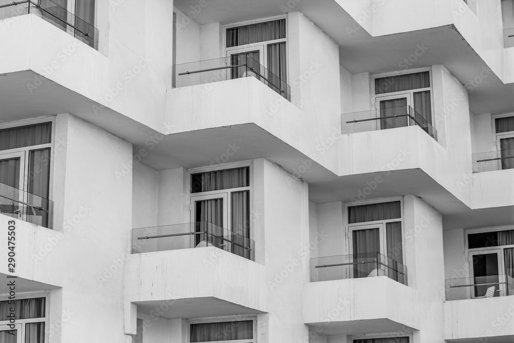 black and white style photography of motel white building dirty walls and perspective windows balcony terraces exterior facade background