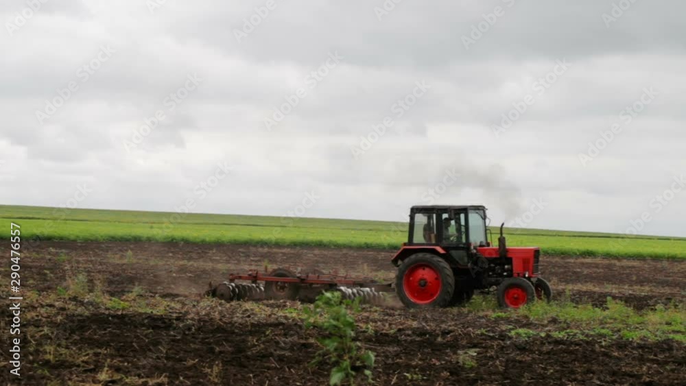 Tractor plowing field and tillage. Scenic agricultural land and farm. Agriculture.