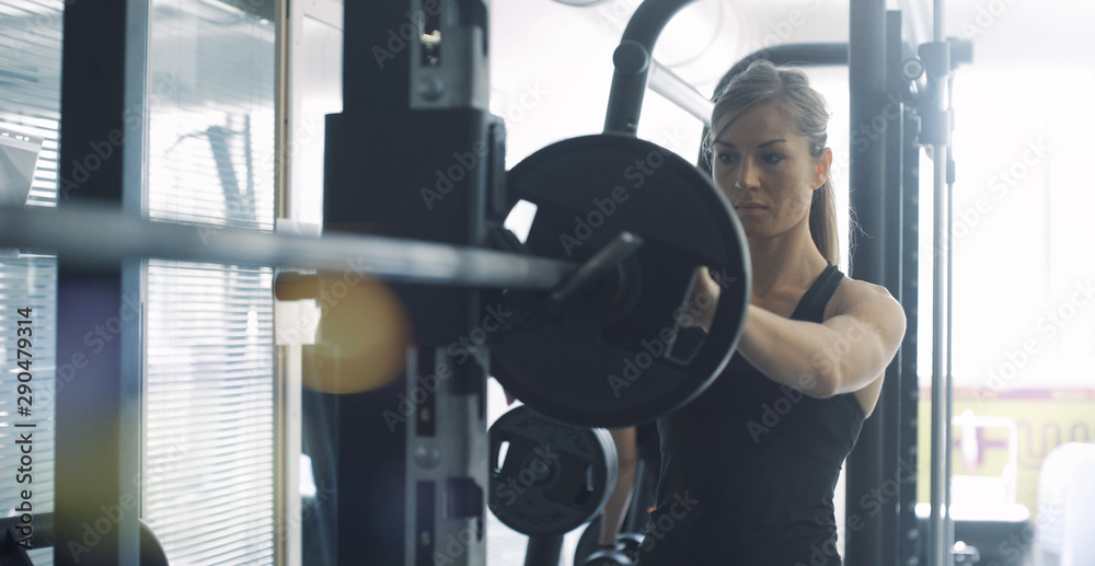 Athletic fit woman weightlifting at the gym Athletic fit woman weightlifting at the gym