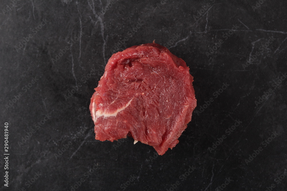 Beef tenderloin. Raw meat on black stone
