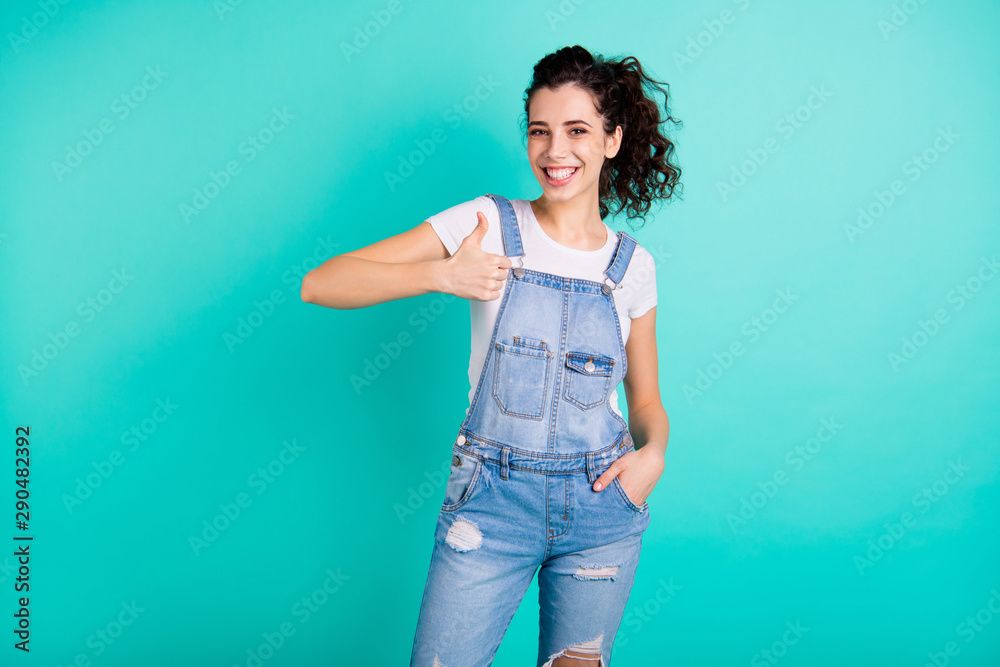 Portrait of her she nice-looking attractive lovely charming cute pretty cheerful cheery wavy-haired girl wearing blue overall showing thumbup isolated on bright vivid shine green turquoise background Portrait of her she nice-looking attractive lovely charming cute pretty cheerful cheery wavy-haired girl wearing blue overall showing thumbup isolated on bright vivid shine green turquoise background