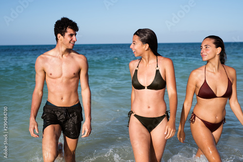 Two girls in bikinis walking in the sea