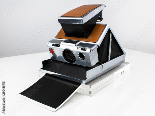 a vintage instant photo camera from the 70s silver with brown leather analog film professional land manual focus slr brown case iconic design nostalgic classic professional photographer travel product photo