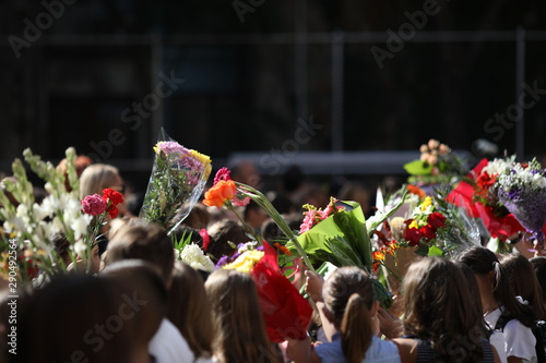 Children hold flowers in their first day of school