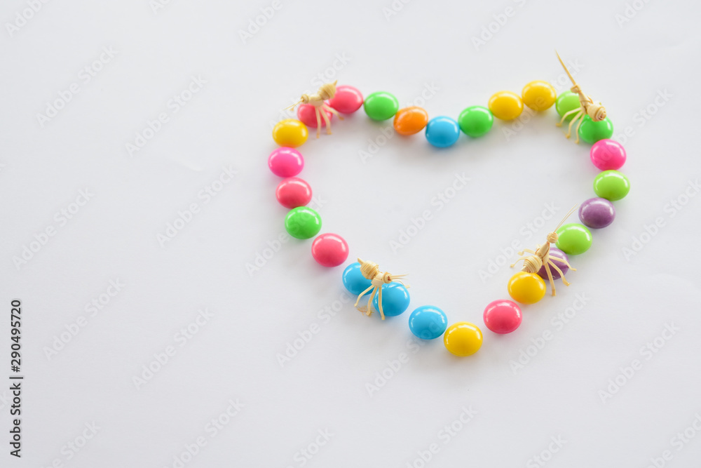 Place colorful candies into concept of heart symbol. Love and colorful concept.
