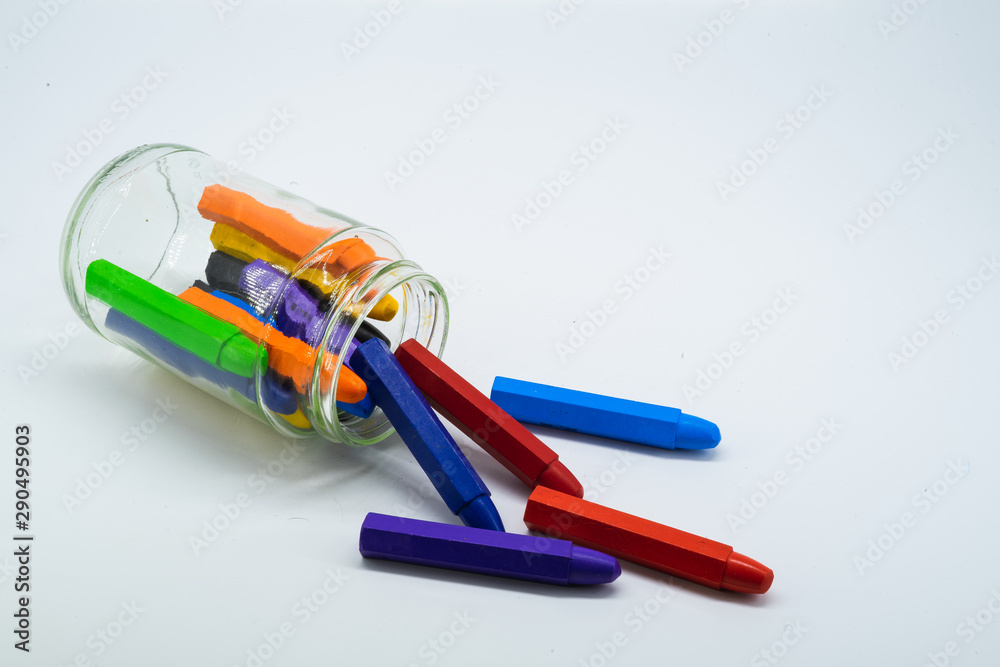 Colourful school supplies, colourful stationery markers in a transparent jar on white background - space for caption Colourful school supplies, colourful stationery markers in a transparent jar on white background - space for caption
