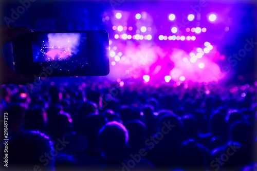 People taking photographs with touch smart phone during a music entertainment public concert