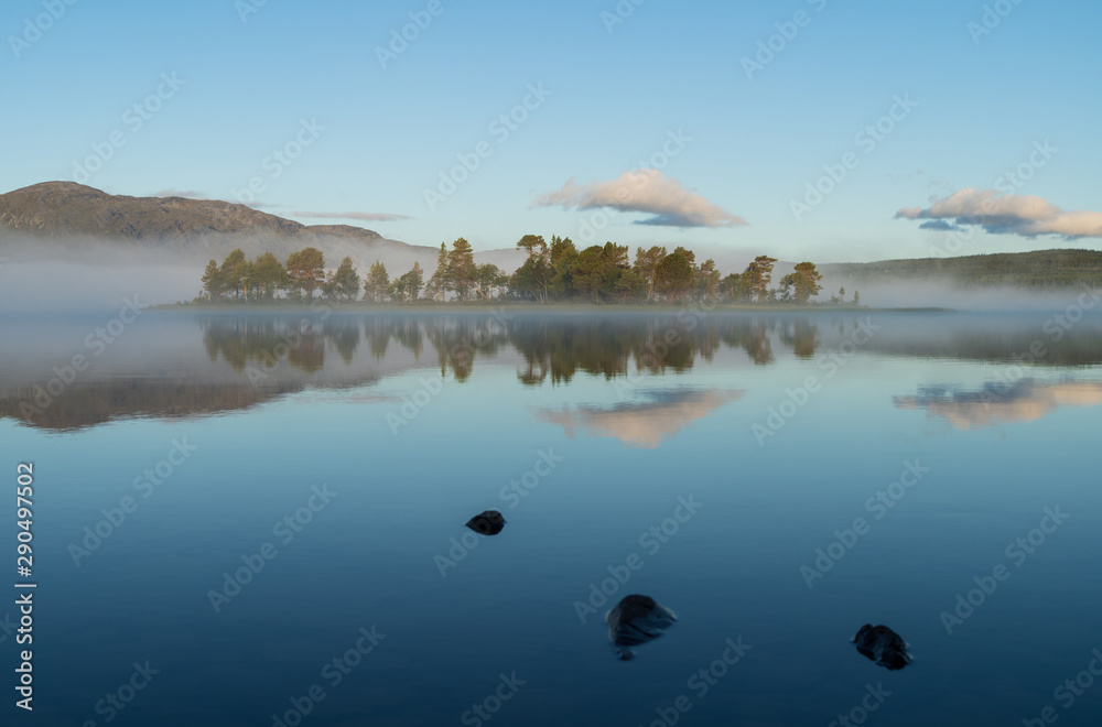 A small island in a lake on a tranquil, foggy morning. Ottsjon, Sweden.