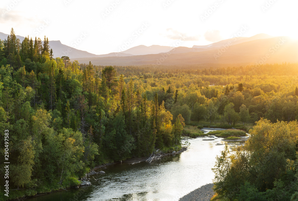 The sun setting over a river in a mountain wilderness. Jamtland, Sweden.