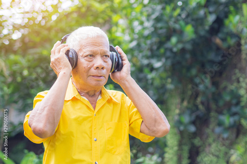 Senior man listen music from wireless headphone