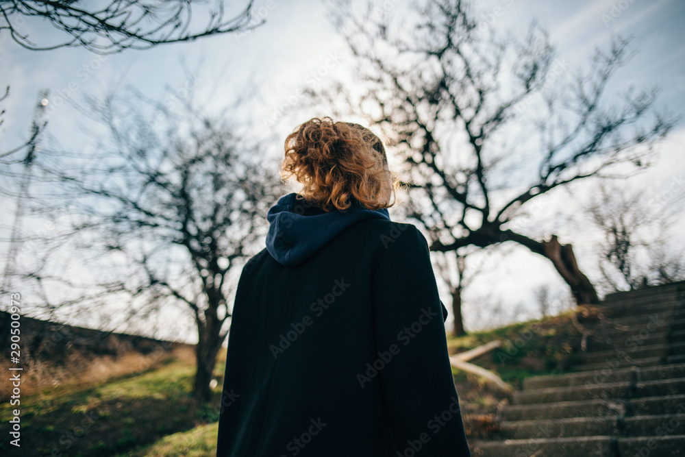 View from the back of a woman in a black coat View from the back of a woman in a black coat