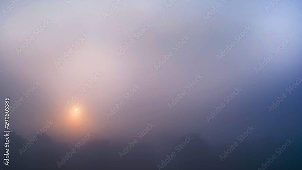 Colored sunrise in forested mountain slope with fog ,View from the mountain in the morning, Surat Thani, Thailand.