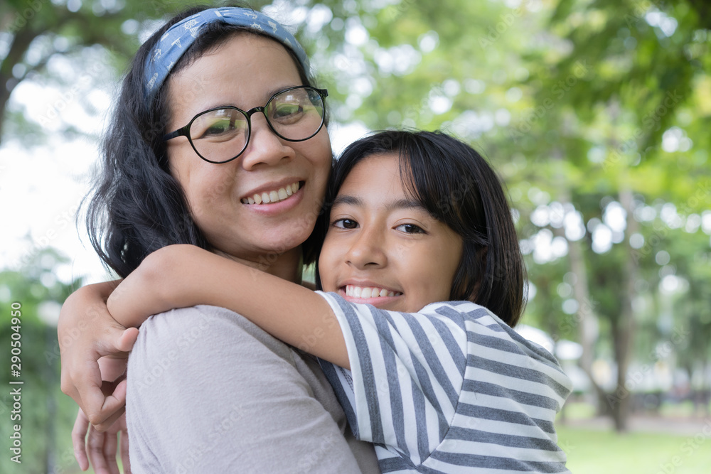 Asian mother and daughter hug each and smiling other at the park, Happy family concept. Asian mother and daughter hug each and smiling other at the park, Happy family concept.