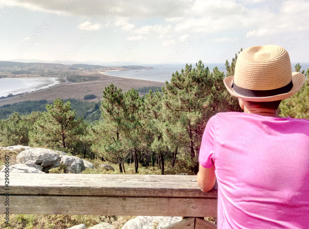 Young hiker woman contemplating landscape from mountain viewpoint