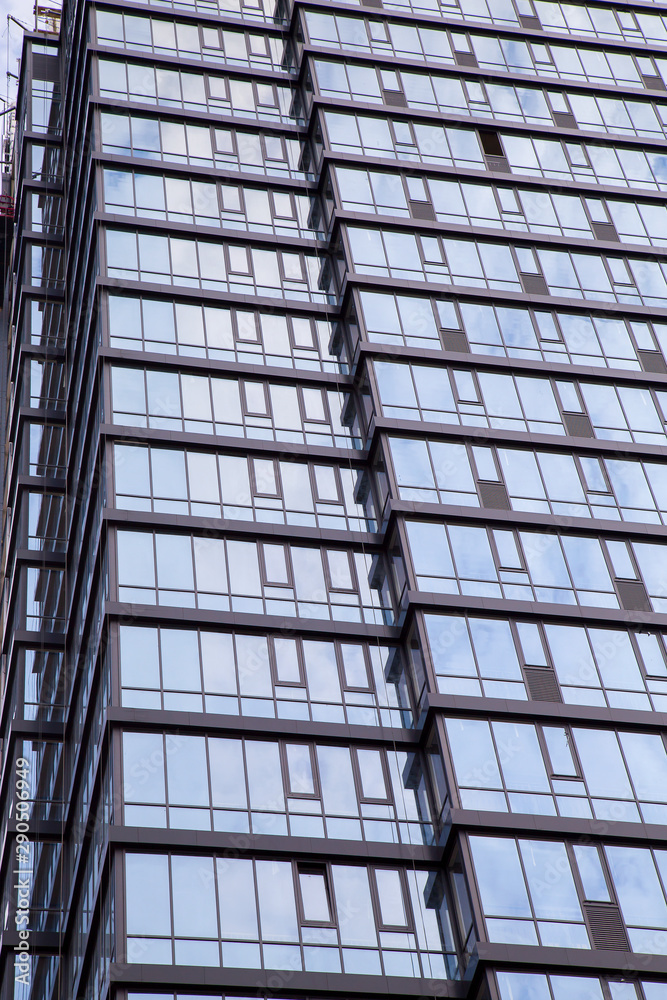 The facade of a modern office building made of glass and concrete..Vertically. The facade of a modern office building made of glass and concrete..Vertically.