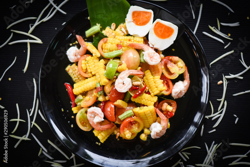 Salad corn spicy with shrimp seafood salted egg fresh vegetables herbs and spices ingredients with chilli tomato peanut garlic served on plate - Slice corn salad papaya som tum Thai menu Asian