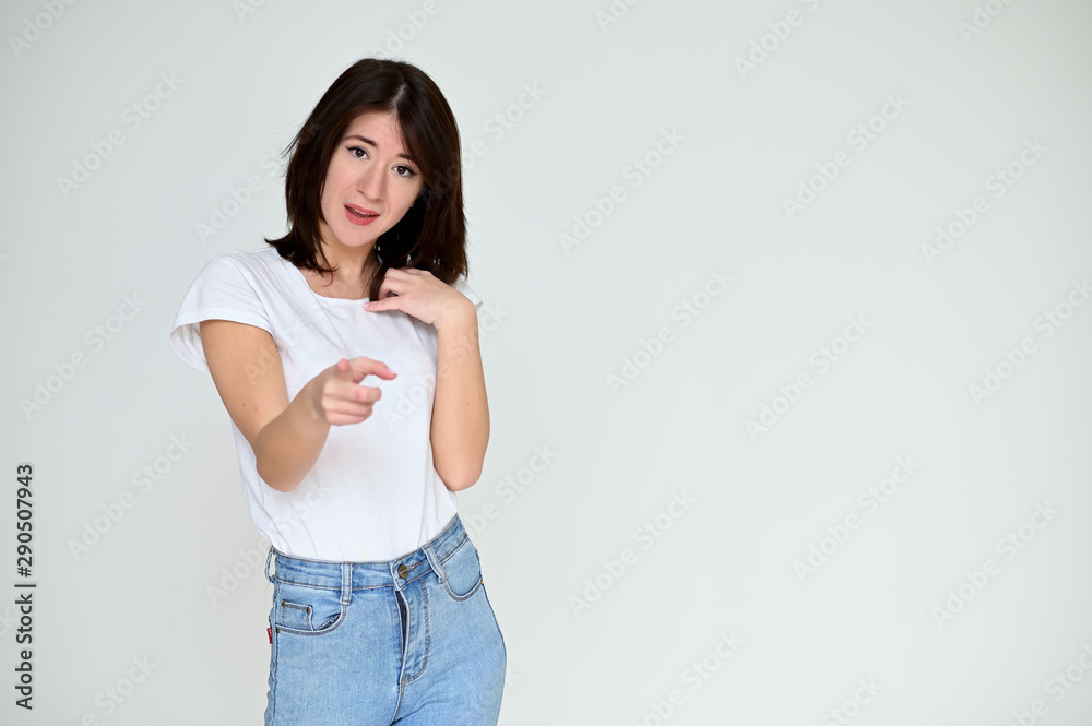 Portrait of a pretty asian brunette girl with black hair in a white t-shirt and blue jeans on a white background. It stands right in front of the camera, with emotions in various poses. Portrait of a pretty asian brunette girl with black hair in a white t-shirt and blue jeans on a white background. It stands right in front of the camera, with emotions in various poses.
