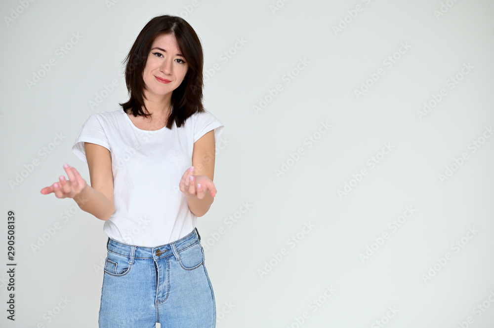 Portrait of a pretty asian brunette girl with black hair in a white t-shirt and blue jeans on a white background. It stands right in front of the camera, with emotions in various poses. Portrait of a pretty asian brunette girl with black hair in a white t-shirt and blue jeans on a white background. It stands right in front of the camera, with emotions in various poses.