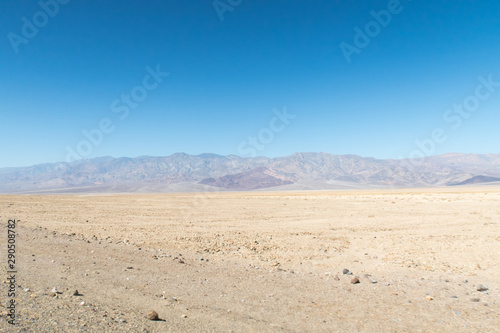 View of a vast Death Valley landscape, empty roads , rock formations and the badwater basin salt deposits.