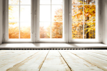 White wooden table and window of autumn landscape 