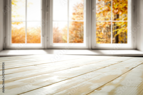 White wooden table and window of autumn landscape 